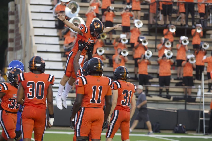 Senior quarterback Brayson McHenry is lifted by teammate senior Qushawn McCulloch after scoring a touchdown against the Tyler High Lions. The Tigers held onto the lead and ended their season opener 24-10 Friday night at Tiger Stadium.