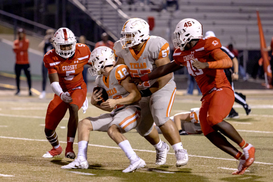 Senior quarterback Brayson McHenry protects the ball as Crosby defenders rush his position. The Cougars limited the Tigers offense a single touchdown in the 5A Division II Quarterfinal game held at Lufkins Abe Martin Stadium on Dec. 3, 2021.