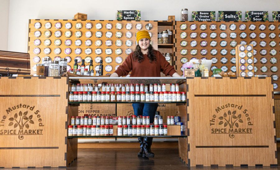At her shop, The Mustard Seed, 2012 graduate Darynn Gay stands before the display of spices. The Mustard Seed carries over 400 types of spices, jams, oils, vinegars, coffee beans, loose-leaf teas and kitchenware. The store is located at 4701 Texas Blvd.