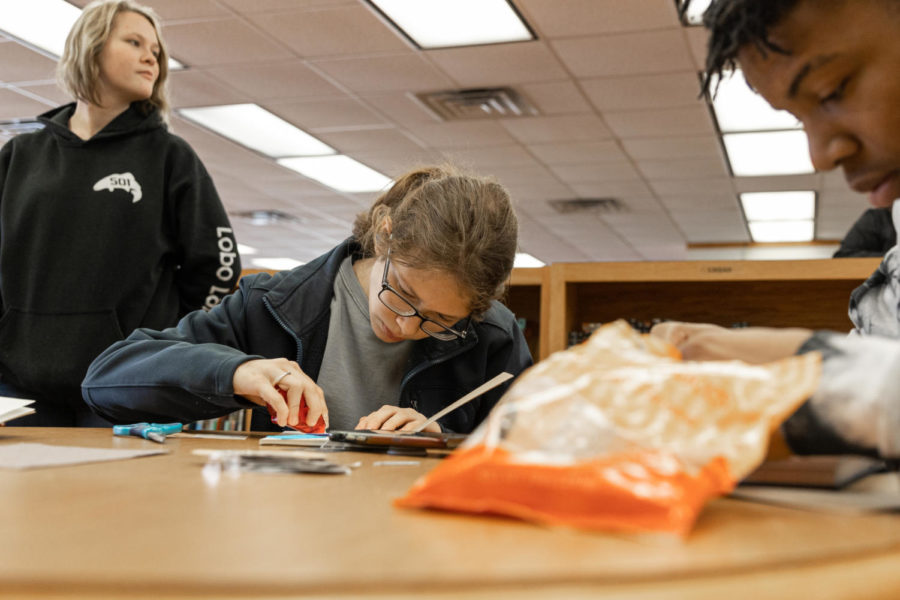 Sophomore Gracie Yates glues pictures into her journal. The library hosted a journaling day on Feb. 4 to teach students and teachers how to journal.