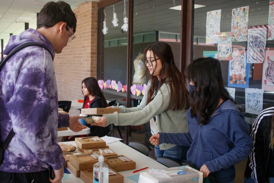 Sophomore Jaden Muniz purchases a pie from Lily Sanchez at the Pi Day bake sale. The Mu Alpha Theta Mathematics Honor Society members sold pies to raise money for scholarships.