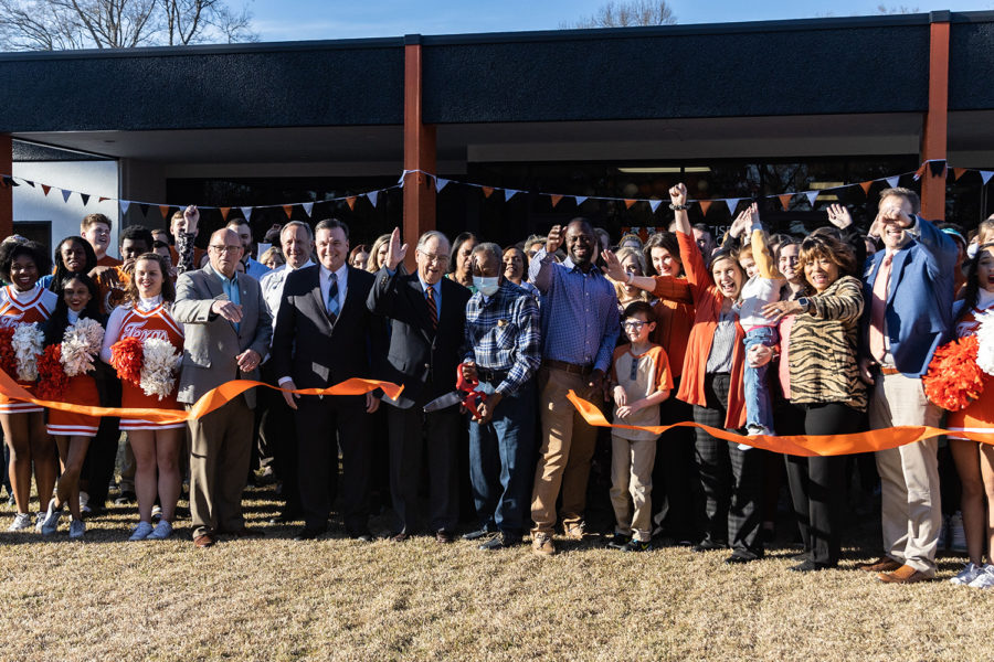 Members+of+TISD+cheer+as+the+orange+ribbon+is+cut%2C+signifying+the+opening+of+the+new+welcome+center.