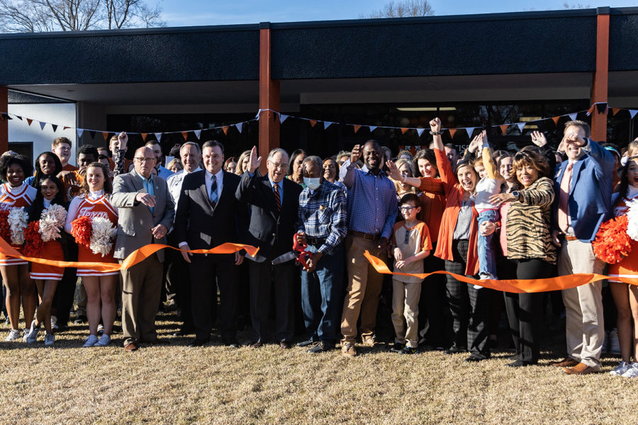 Members of TISD cheer as the orange ribbon is cut, signifying the opening of the new welcome center.