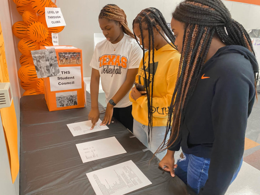 Juniors Aamireyon Moore, Keira Thomas and  Senae Walker read over the requirements needed to join THS Student Council. Clubs set up booths around the cafeteria in attempt to bring in new members.