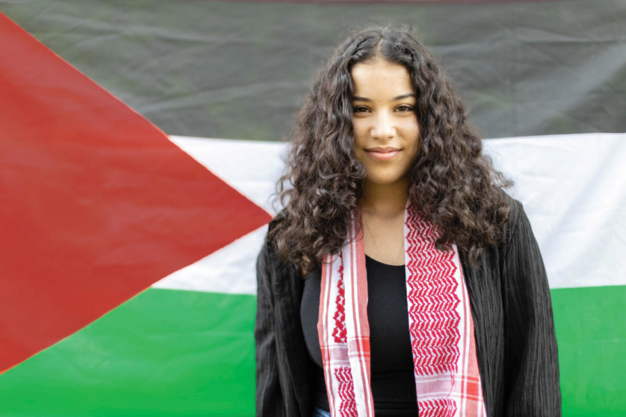 Yosra Nseirat stands in front of the Palestine flag proud to be Middle Eastern.