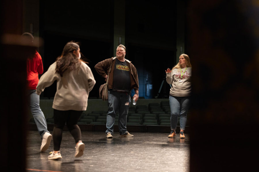 Teacher Brandon Shoemaker stands onstage as he helps direct Clue. Despite being new to the Tiger Theatre company, this English teacher is not new to the stage.