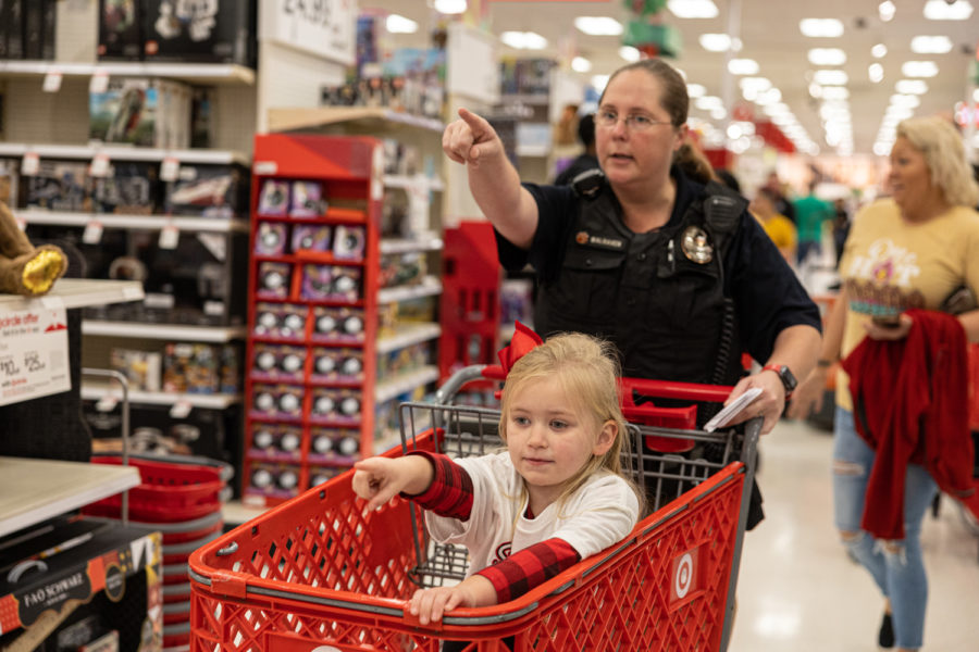 Nash+officer+Stephanie+Walraven+points+in+affirmation+with+her+shopper+to+go+to+the+toy+section+at+Target.+Children+and+first+responders+packed+the+aisles+of+the+store+during+the+shopping+event.+