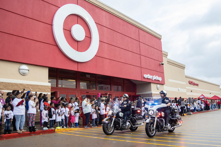 Shop with a Cop shoppers wave as the police drive by on motorcycles. Lights and sirens signaled the start of the shopping event.