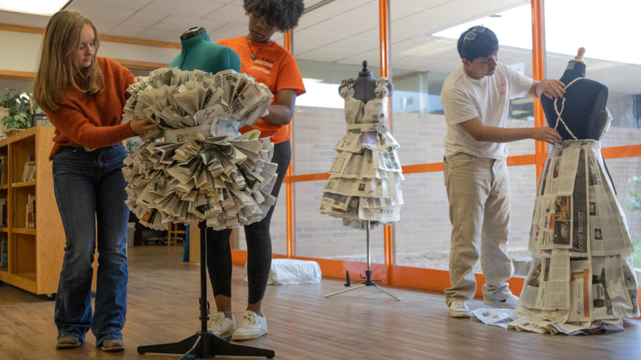 Texas High students set up a fashion design exhibit in the library. They repurposed newspapers to create amazing outfits.