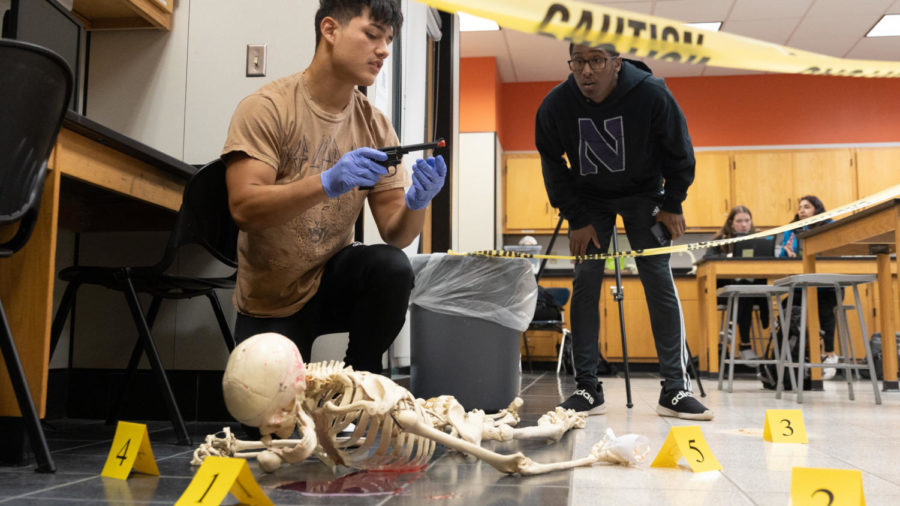 Seniors Alejandro Cardenas and Dominic West investigate a mock crime scene. In Forensic Science, students learn to put their science skills into practice.