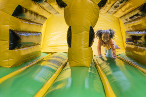 Dunbar student Nova Dawson races out of inflatable obstacle course tunnel at the Leader In Me Hall of Fame carnival. Numerous students were celebrated for their achievements from the past year.