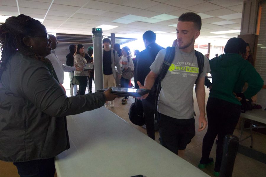 Junior Adam McCarter grabs his chromebook after passing through metal detectors on Monday, May 15. Students go through the metal detectors before they enter class.