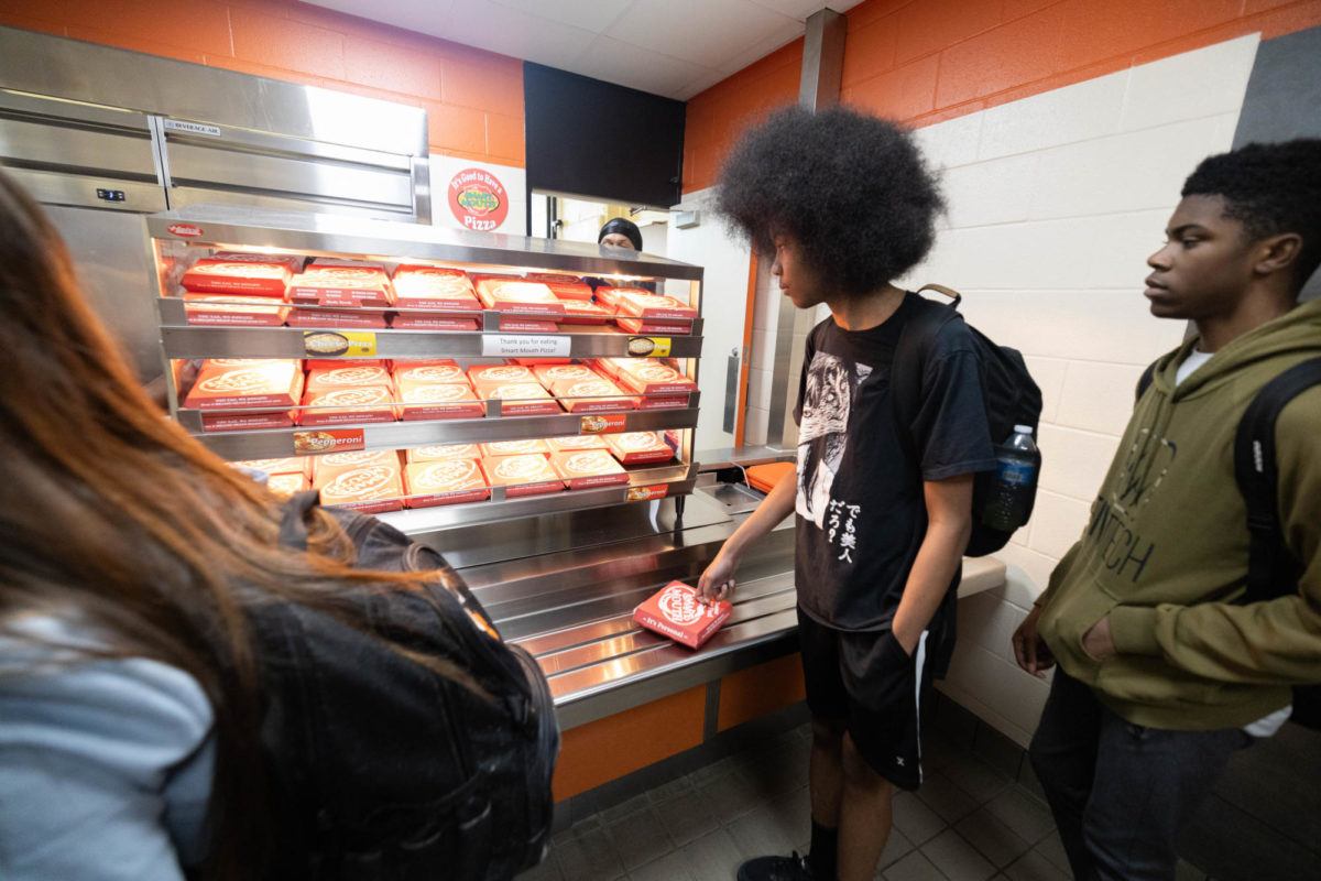 Pizza in hand, senior Nevar McCoy walks through the pizza line in the cafeteria on Sep 20, 2023. The pizza line is the newest addition to the variety of food offered at Texas High. 
