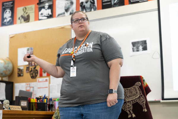 Erika Delk motions to change the slides while teaching one of her classes on Sep. 28, 2023. Delk graduated from Texas High and is now a U.S. History teacher.