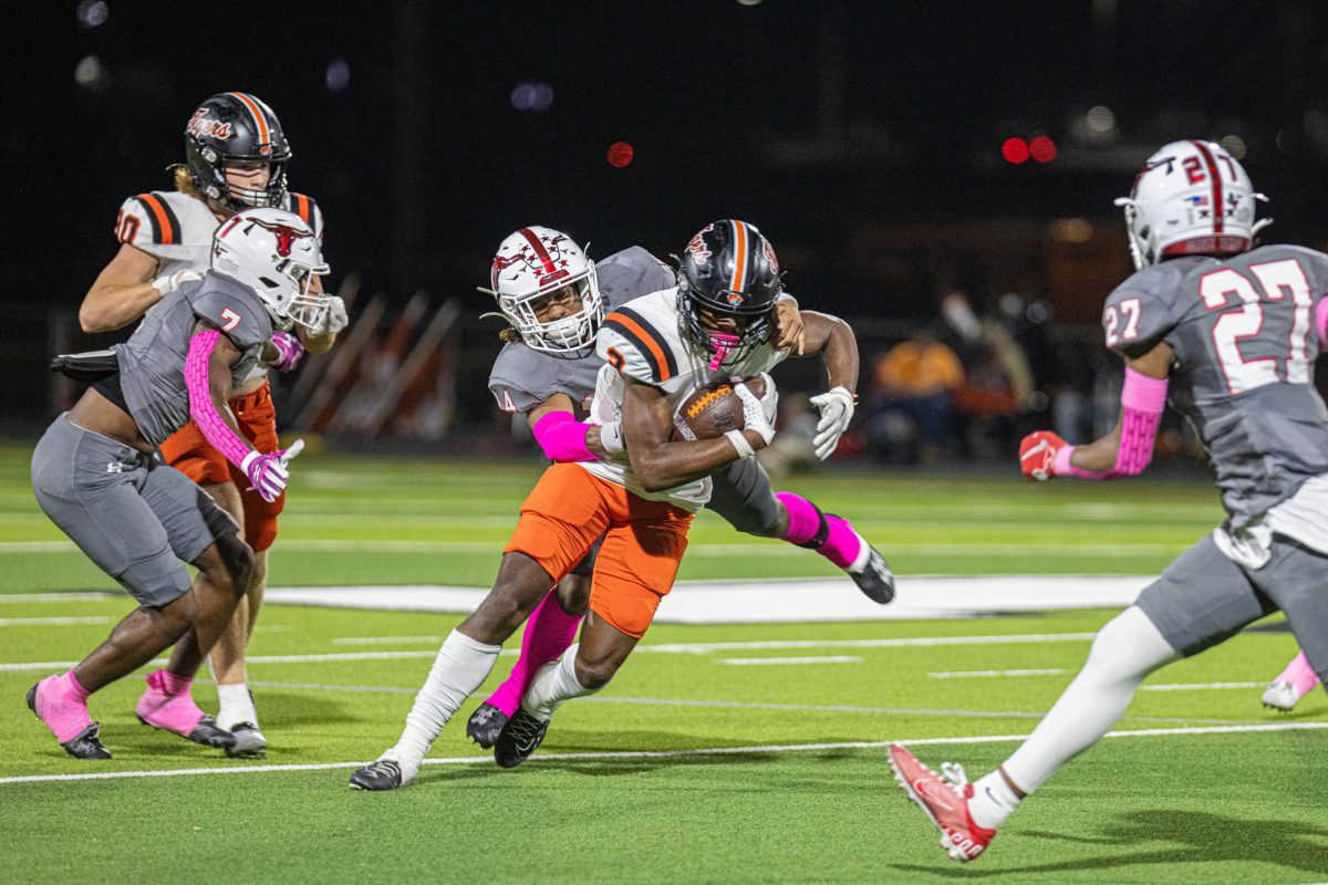 Sophomore Tradarian Ball runs with a Maverick on his back in the rivalry game against the Marshall Mavericks Friday, Oct. 13, 2023. The Tiger offense picked up during the back half of theme, putting them on top with a final score of 30-7. 