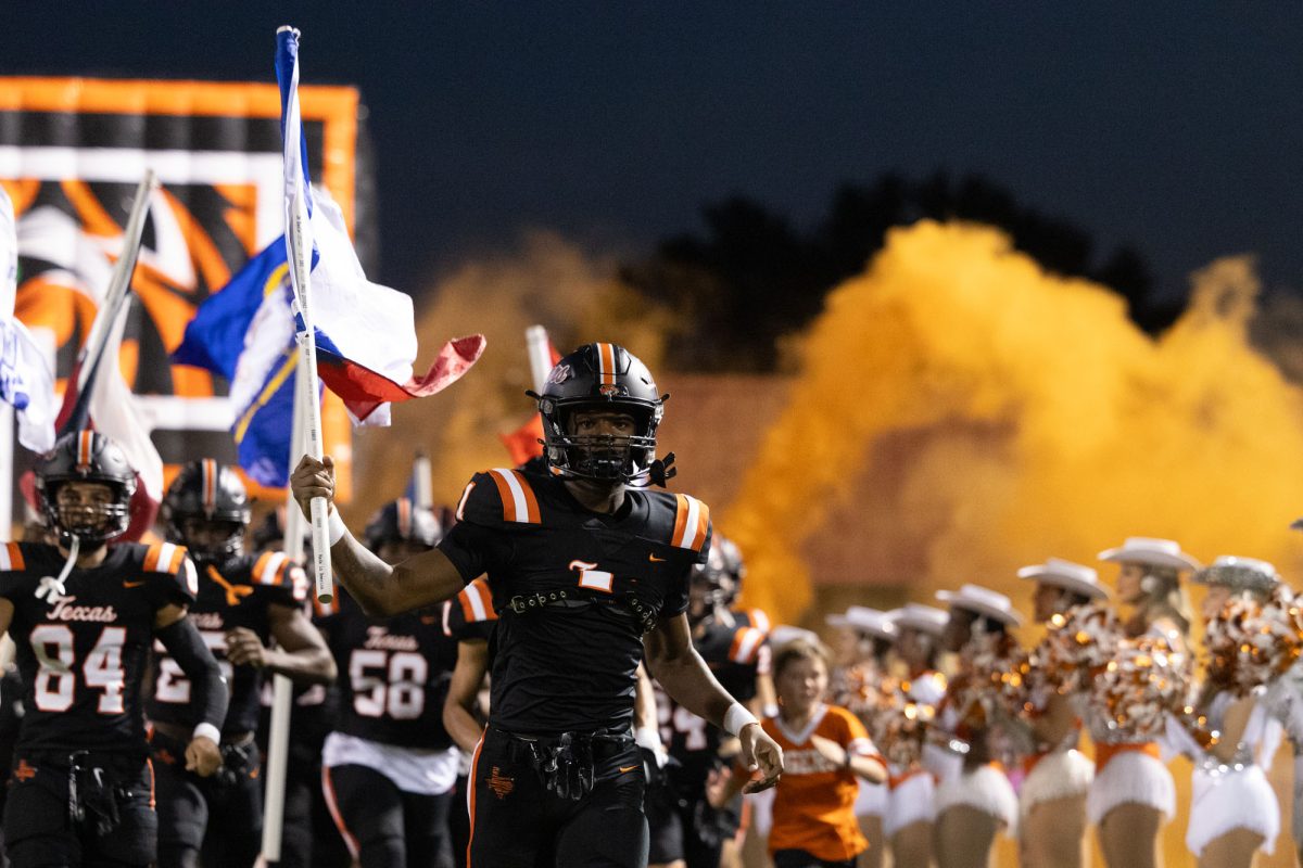 Senior TJ Gray runs the Texas flag out the Texas High tunnel to kick off the Homecoming game Friday, Sept. 29, 2023. The Tigers faced Mount Pleasant at home for their Homecoming match-up.