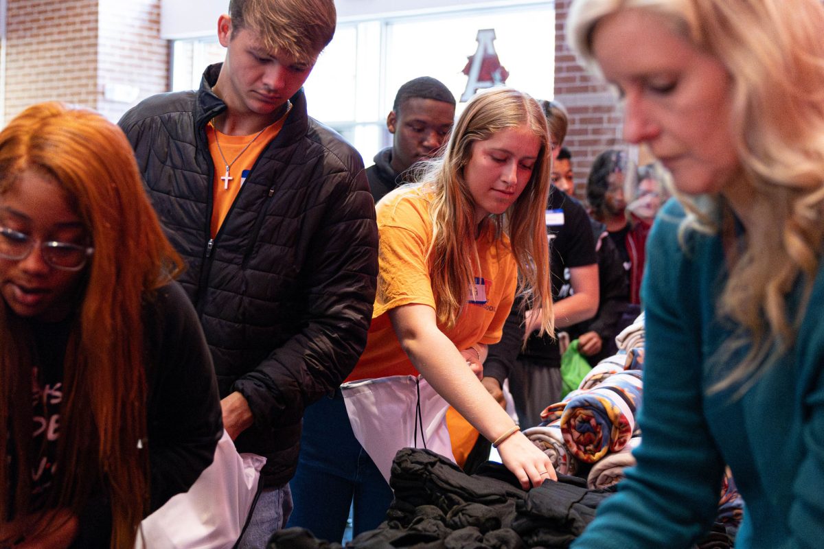 Senior Jenna Humphrey reaches for a pair of socks to fill her a bag. Student Council filled one bag each with necessities for the homeless population of Texarkana on Nov. 15, 2023.