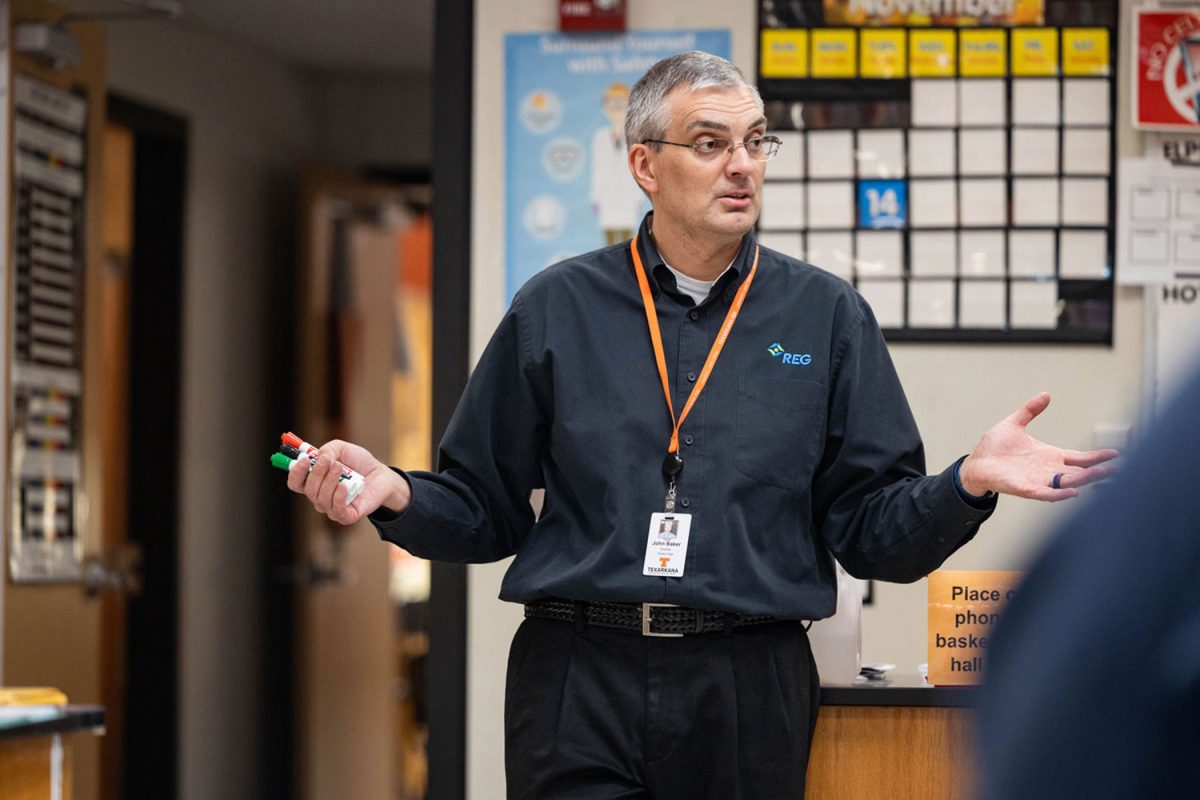 Looking towards his class, science teacher John Baker teaches in his classroom. Baker immigrated from Russia 23 years ago and married Amy Baker, fellow science teacher.