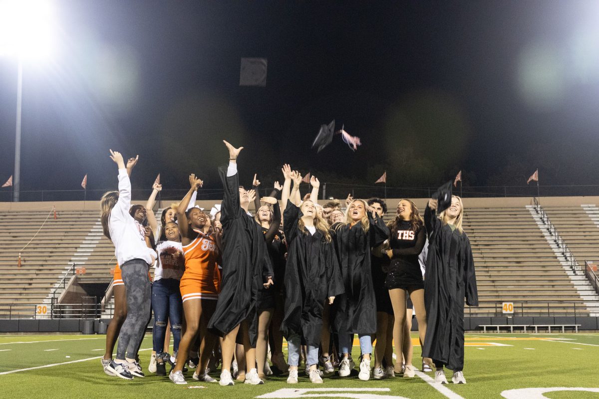 Seniors throw caps and gowns into the air after their senior skit. The seniors performed to several songs in tradition with the first playoff game pep rally.