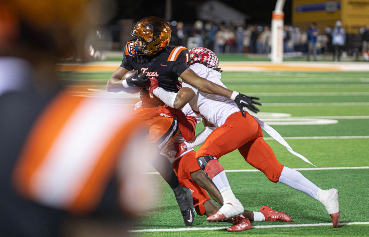 Senior receiver TJ Gray takes a tackle from two Terrell Tigers. The Tiger offense managed 51 points on the night, outscoring Terrell by 23 points.
