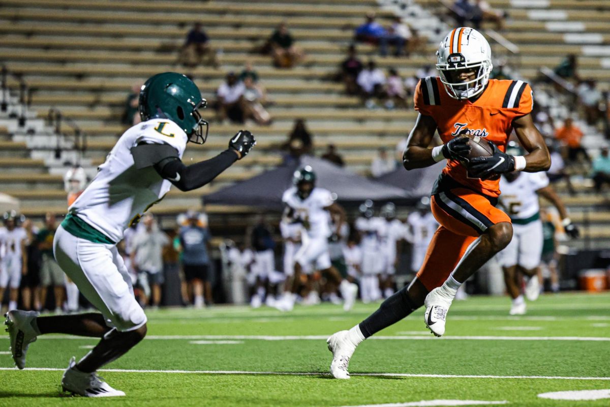 Senior wide receiver, TJ Gray, dodges Longviews defense in the first scrimmage of the season. The Texas Tigers played the Longview Lobos at Tiger Stadium at Grim park.