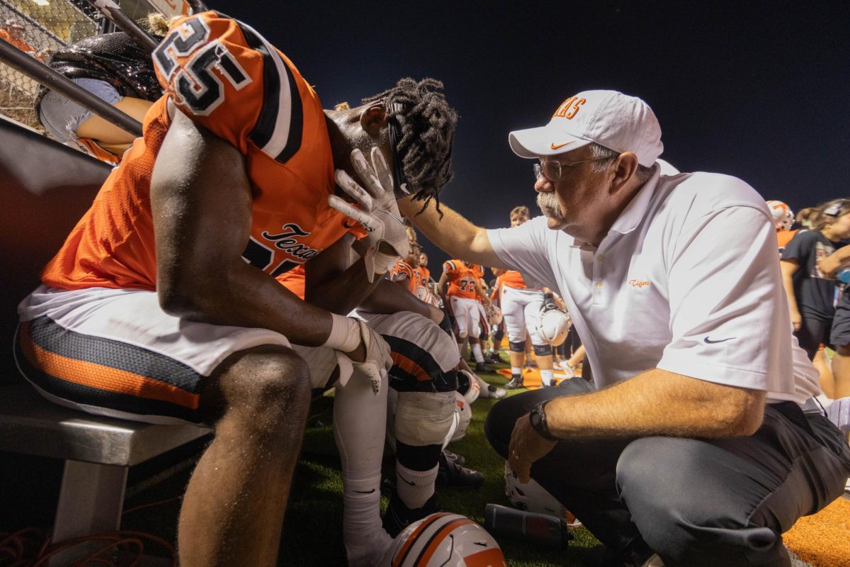 Senior Joseph Miller is comforted by a coach in a game against Lonestar Friday, Aug. 24, 2023. The Tigers came out victorious in their season opener with a final score of 41-37. 
