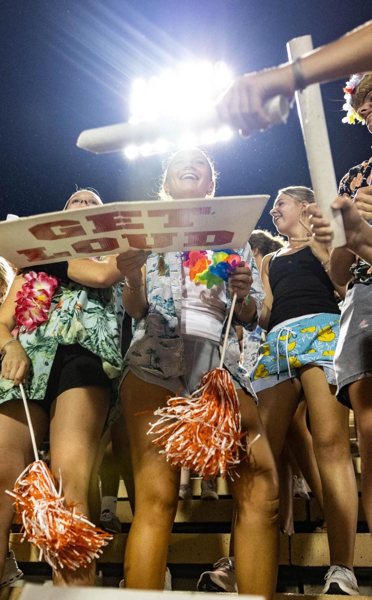 Senior Annabeth Killian holds a Get Loud sign in the student section Friday, Aug. 24, 2023. The Texas High student section had a Hawaiian theme for the game. 
