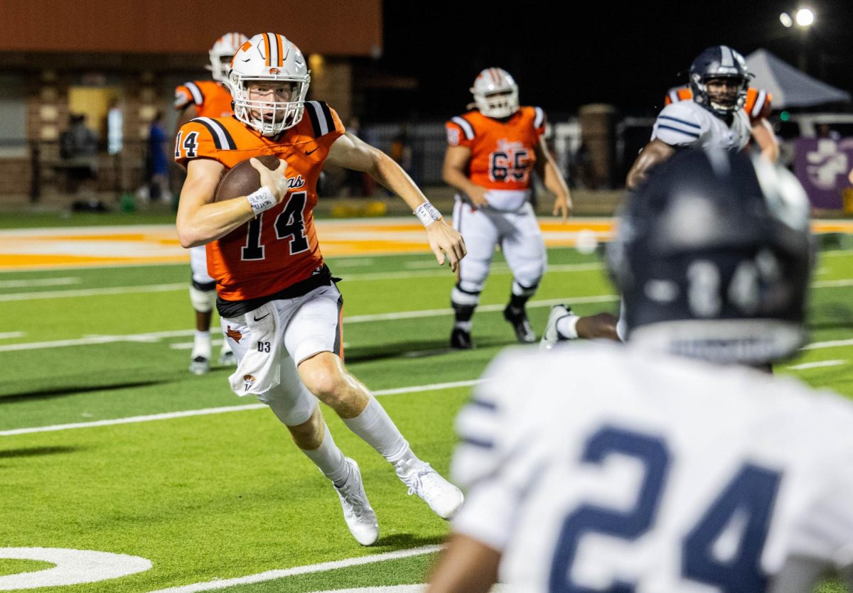 Junior quarterback, David Potter, weaves between defensive obstacles put on by the Frisco Lone Star Rangers. The Tigers squeezed out a victory over the Rangers with a score of 48-40.