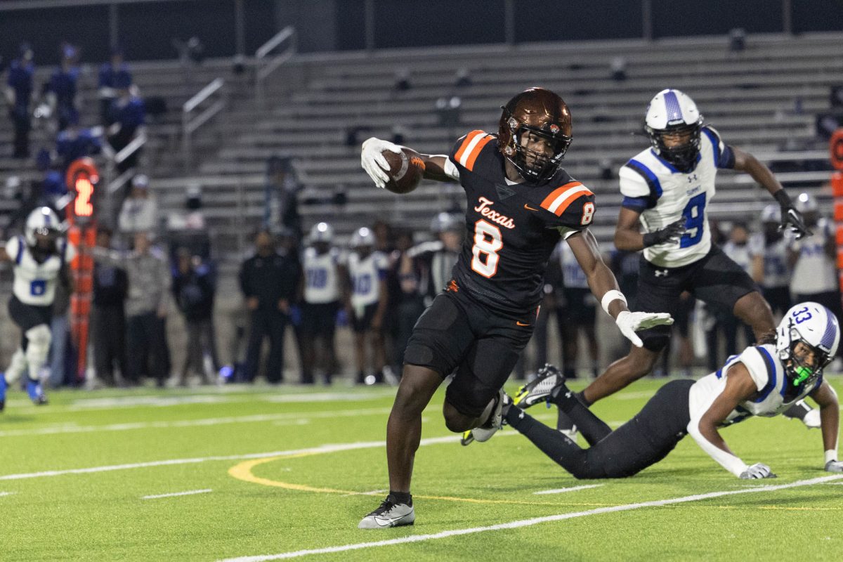 Arms wide, sophomore receiver Shavante Montgomery runs the football during their game against Mansfield Summit on Nov. 17, 2023. The Tiger offense started off shaky, but managed to gain momentum and score in the second half.