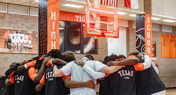 The Tigers huddle up in prayer during the pregame events for their game against eStem Charter Thursday, Nov. 30, 2023.  The Tigers fell to the Mets at home. 