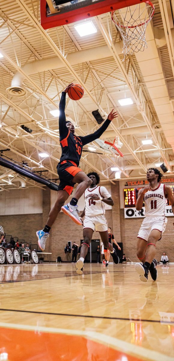 Junior Jimon Haynes leaps as he tries to score a basket in the rivalry game against Arkansas High Saturday, Dec. 2, 2023. The Tigers took the victory in the crosstown rivalry. 