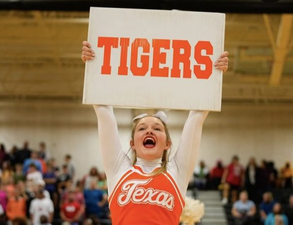Senior varsity captain Nealy Kate Anderson holds up a sign at a Texas High pep rally. Nealy was honored as the cheer Face of the Game.
