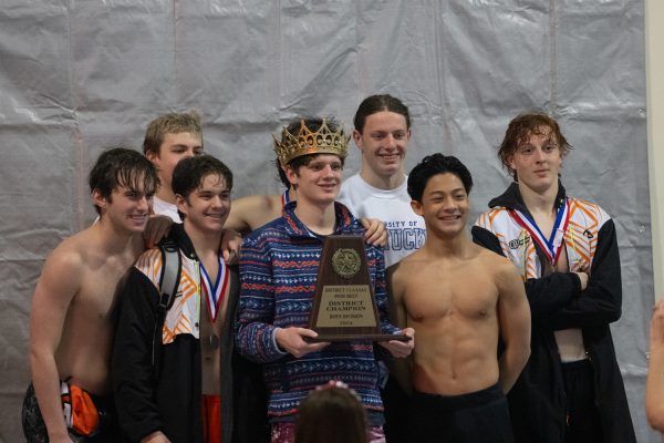 Max Likins holds the District 15-5A championship trophy while posing with other members of the boys Tigershark team. Likins and twenty-one other members of the boys and girls team qualified for the regional swim meet New Canney, Texas on Feb. 9 and 10, 2024.
