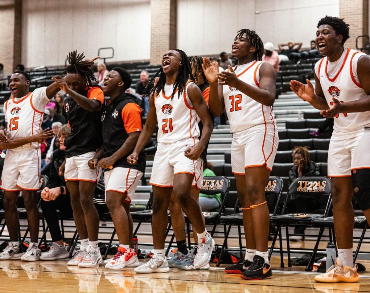 Junior+Alex+Jones+and+freshman+Quay+Ford+celebrate+for+their+teammates+in+a+district+match+again+the+Marshall+Mavericks+Dec.+19%2C+2023.+The+Tigers+defeated+the+Mavericks.