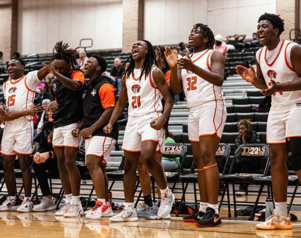 Junior Alex Jones and freshman Quay Ford celebrate for their teammates in a district match again the Marshall Mavericks Dec. 19, 2023. The Tigers defeated the Mavericks.