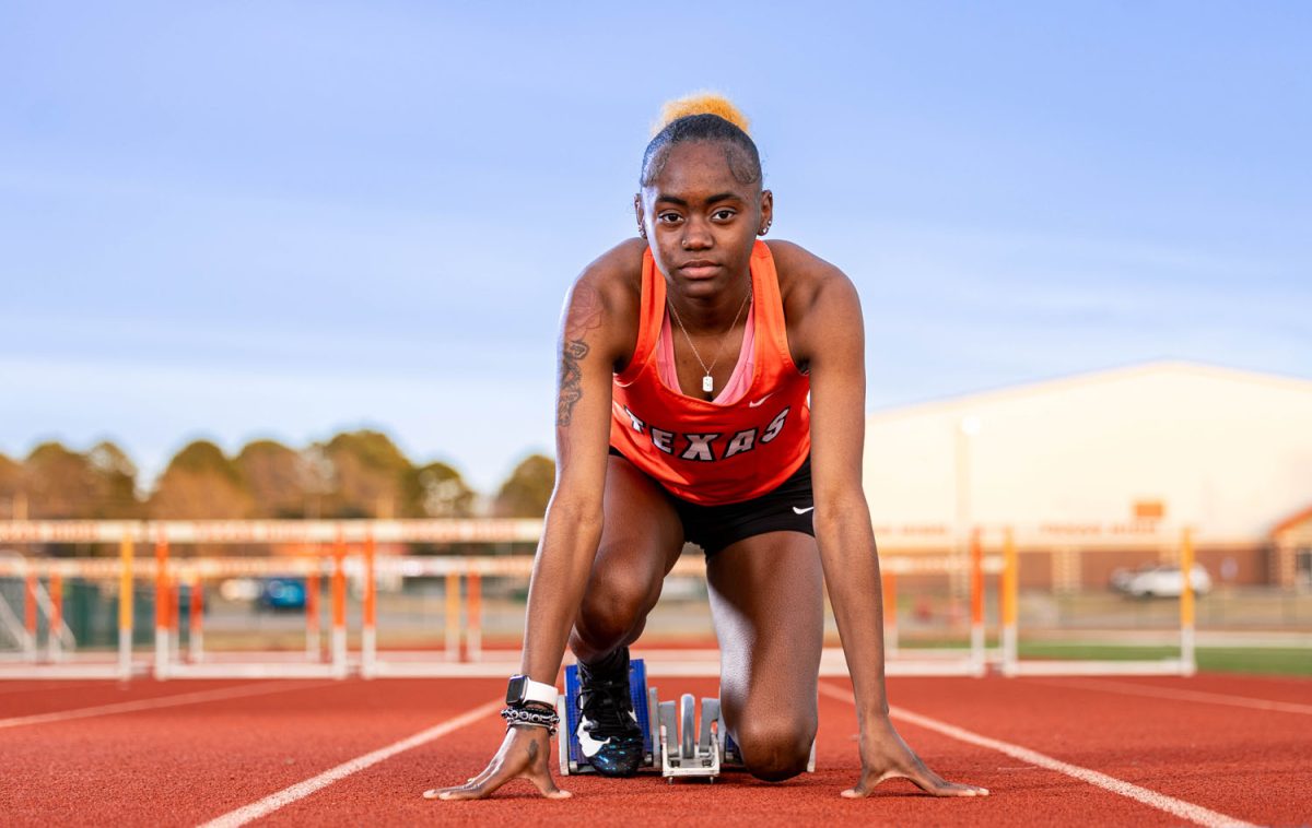 Senior Jayla Henderson settles into her blocks as she would before running her race. Henderson is returning from her third ACL tear to compete.