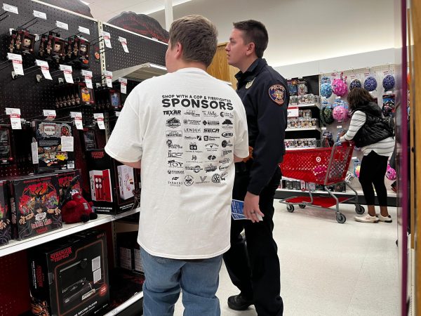 Shop With a Cop participant Preston King converses with Detective James Ward while shopping for Christmas gifts. On Dec. 2, 2025, numerous branches of law enforcement joined forces this Christmas season, bringing joy to children in need through gifts and festive experiences.