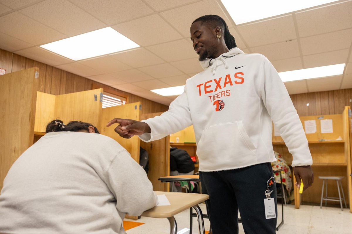 Jaylen Rhone smiles as he wakes up a student. Rhone’s lack of an educator role prior to coming to Texas High gave him a fresh slate to learn and gain experience.
