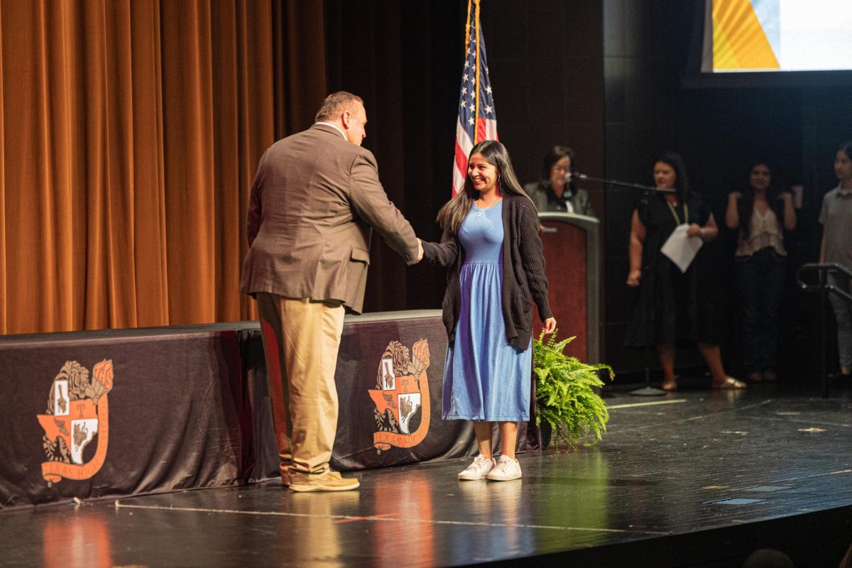 Junior Yeybeth Zacarias shakes Ben Renner's hands after accepting her award. On May 7, 2026, students accepted awards from their teachers during the annual Academic Awards Assembly.
